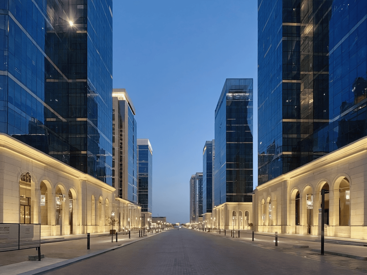 Visuel d’inspiration — Avenue d'affaires au crepuscule : tours de verre et arcades de pierre eclairees.