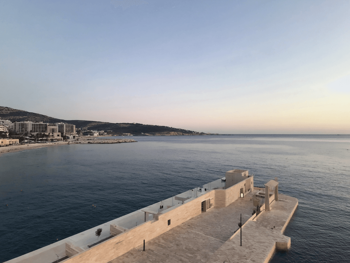 Visuel d’inspiration — Baie au coucher du soleil : esplanade de pierre avancant sur la mer.